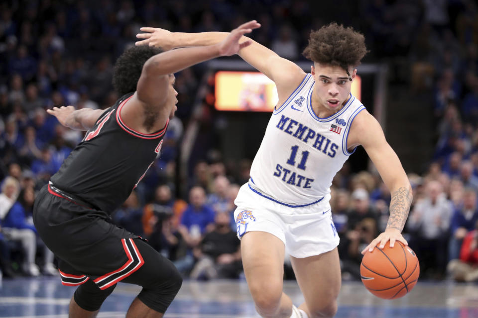 Memphis guard Lester Quinones (11) drives the ball around Georgia guard Sahvir Wheeler (15) in the second half of an NCAA college basketball game Saturday, Jan. 4, 2020, in Memphis, Tenn. (AP Photo/Karen Pulfer Focht)