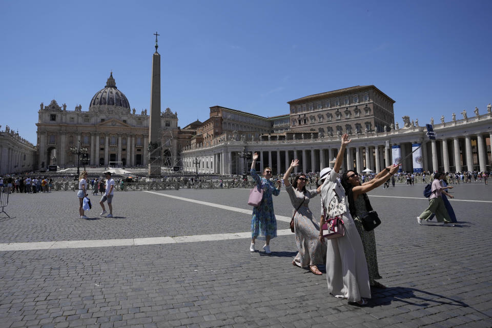 People take selfie photos in front of St. Peter's Basilica at The Vatican in Rome, Thursday, June 8, 2023, the day after Pope Francis underwent surgery to repair a hernia in his abdominal wall, the latest malady to befall the 86-year-old pontiff who had part of his colon removed two years ago. (AP Photo/Alessandra Tarantino)