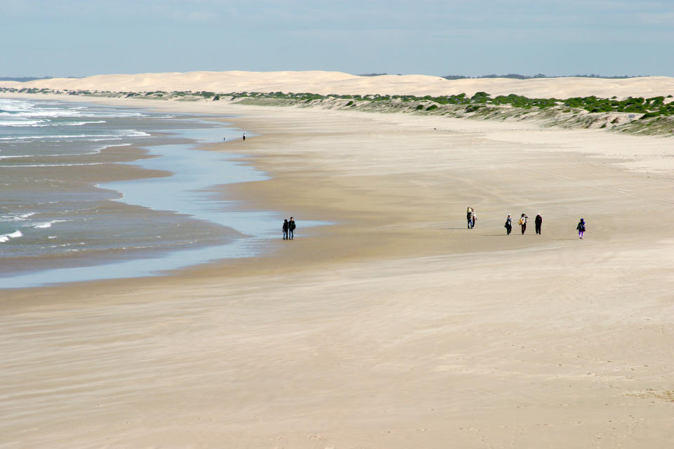 People walk on the beach in Port Stephens in NSW 