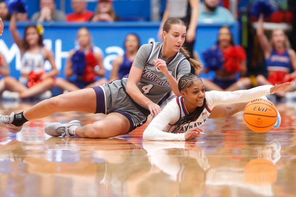 Kansas guard Wyvette Mayberry (0) reaches for a loose ball against Kansas State's Serena Sundell (4) during the Sunflower Showdown game Sunday at  Allen Fieldhosue.