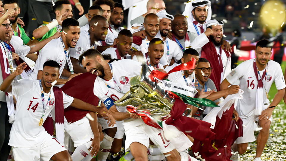 Qatar’s players celebrate with the trophy. (Photo by ROSLAN RAHMAN/AFP/Getty Images)