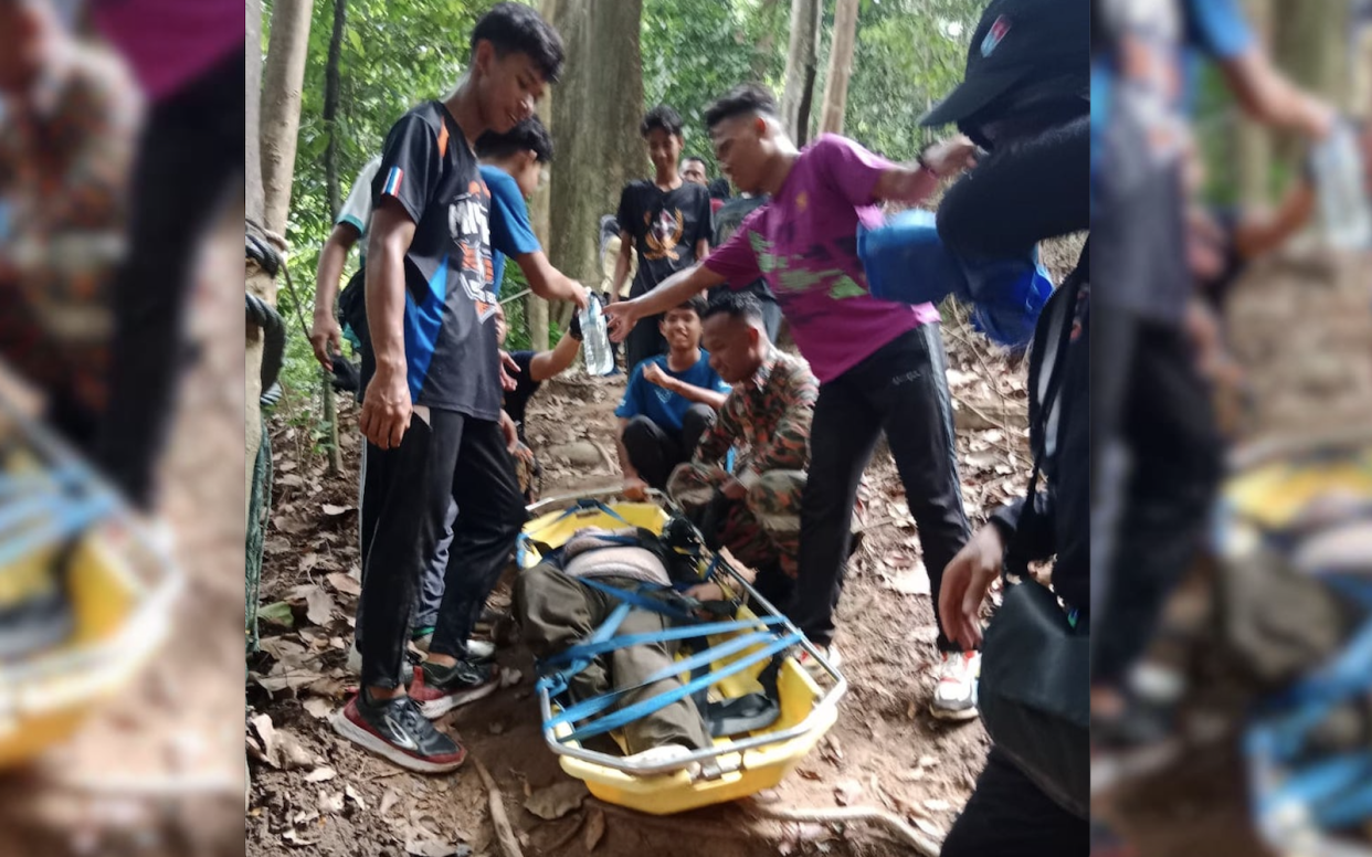 A woman being stretchered surrounded by people who helped her.