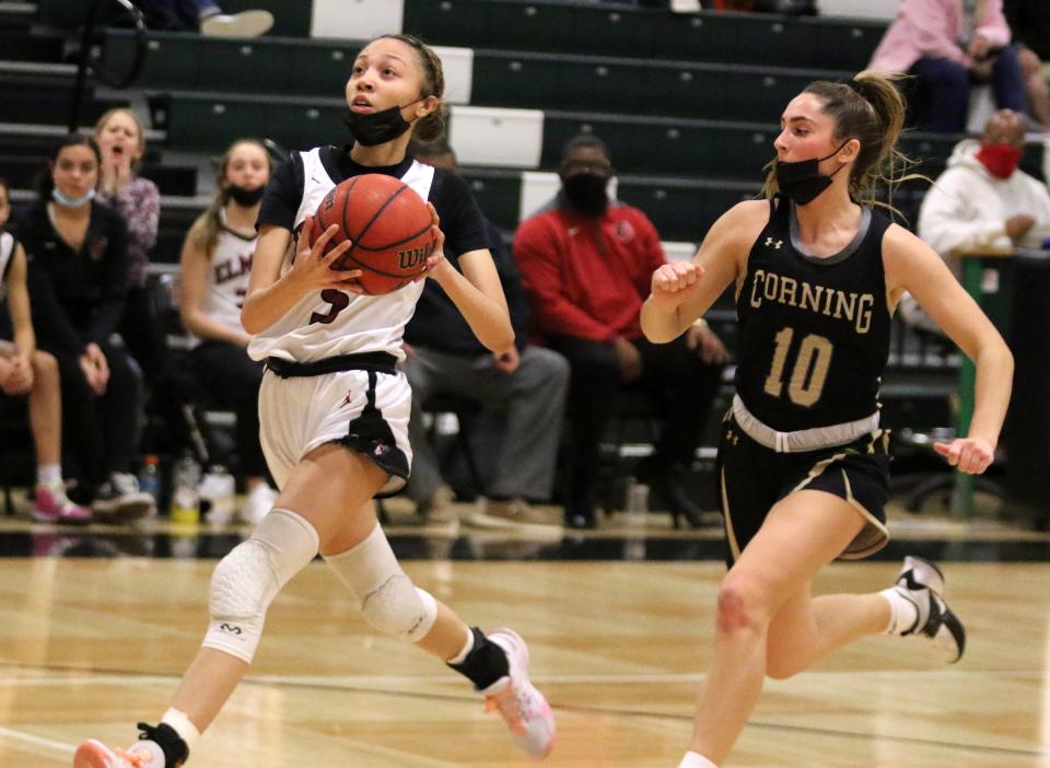 Jalea Abrams of Elmira goes in for a layup ahead of Corning's Jenna DiNardo during the Express' 75-49 win in girls basketball Jan. 11, 2022 at Elmira High School.