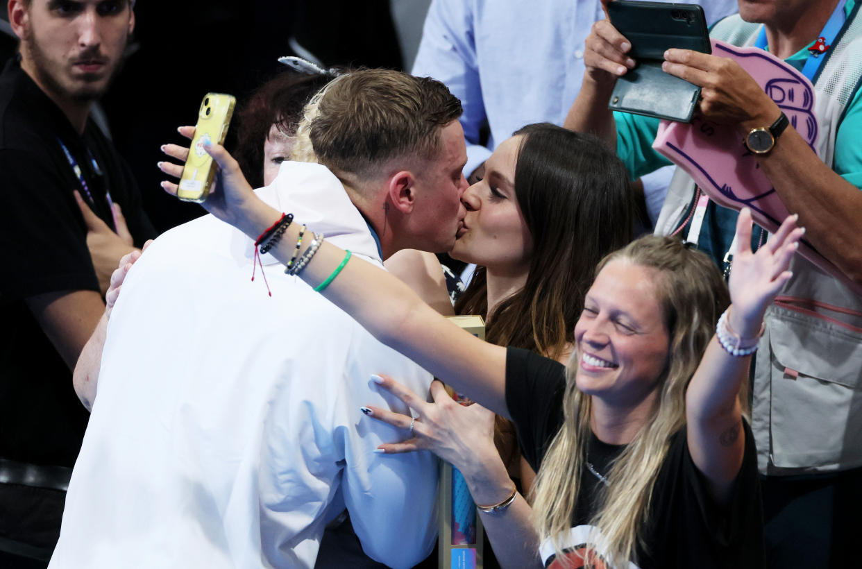 Adam Peaty kisses his partner, Holly Ramsay following the Swimming medal ceremony. (Getty)