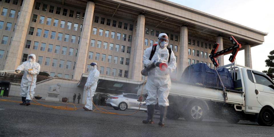 Employees from a disinfection service company sanitize outside the National Assembly in Seoul, South Korea, February 24, 2020.  Yonhap via REUTERS  