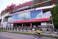 A cyclist passes by Nissan Stadium, home of the Tennessee Titans, Tuesday, Sept. 29, 2020, in Nashville, Tenn. The Titans suspended in-person activities through Friday after the NFL says three Titans players and five personnel tested positive for the coronavirus, becoming the first COVID-19 outbreak of the NFL season in Week 4. (AP Photo/Mark Humphrey)