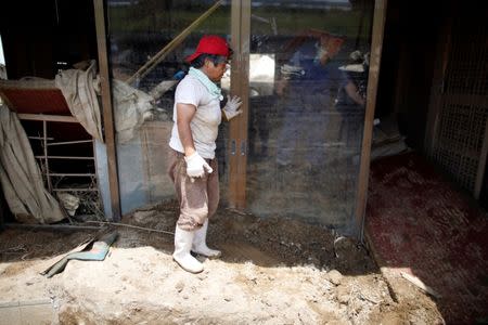 Family members of 63-year-old Atsushi Yamashita (not pictured) try to remove mud and debris form his destroyed house in a flood affected area in Mabi town in Kurashiki, Okayama Prefecture, Japan, July 13, 2018. REUTERS/Issei Kato