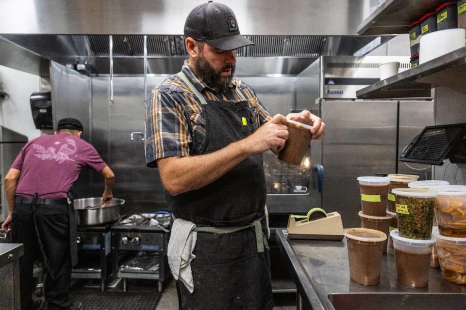 Cantina Pedregal’s co-owner Brad Cecchi labels ingredients for dishes in the new restaurant in Folsom on Tuesday.
