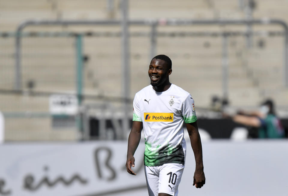 Moenchengladbach's Marcus Thuram smiles after scoring his side's third goal during the German Bundesliga soccer match between Borussia Moenchengladbach and Union Berlin in Moenchengladbach, Germany, Sunday, May 31, 2020. The German Bundesliga becomes the world's first major soccer league to resume after a two-month suspension because of the coronavirus pandemic. (AP Photo/Martin Meissner, Pool)