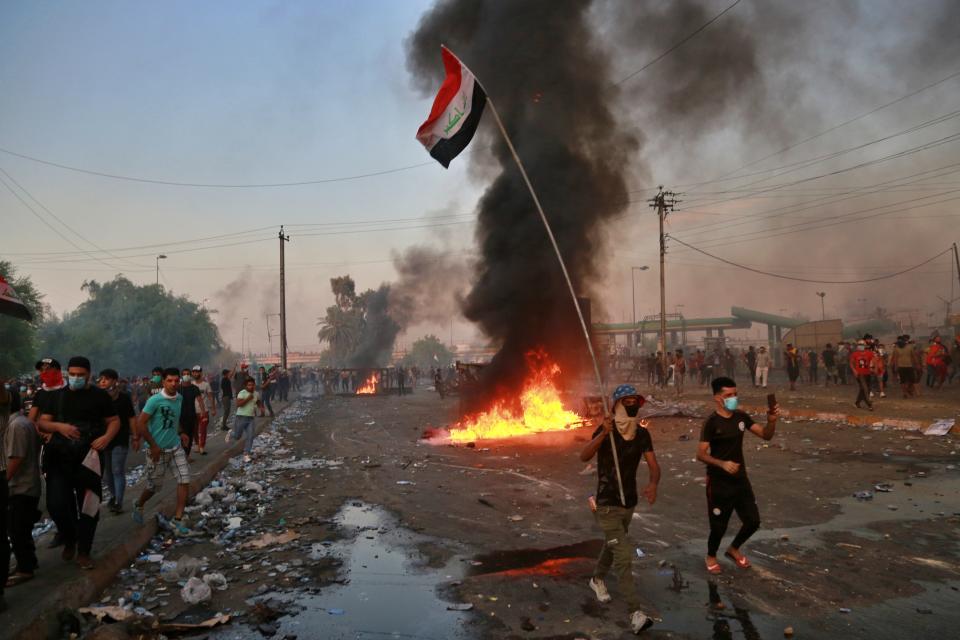 Anti-government protesters set fires and close a street during a demonstration in Baghdad, Iraq, Thursday, Oct. 3, 2019. Iraqi security forces fired live bullets into the air and used tear gas against a few hundred protesters in central Baghdad on Thursday, hours after a curfew was announced in the Iraqi capital on the heels of two days of deadly violence that gripped the country amid anti-government protests that killed over 19 people in two days. (AP Photo/Hadi Mizban)