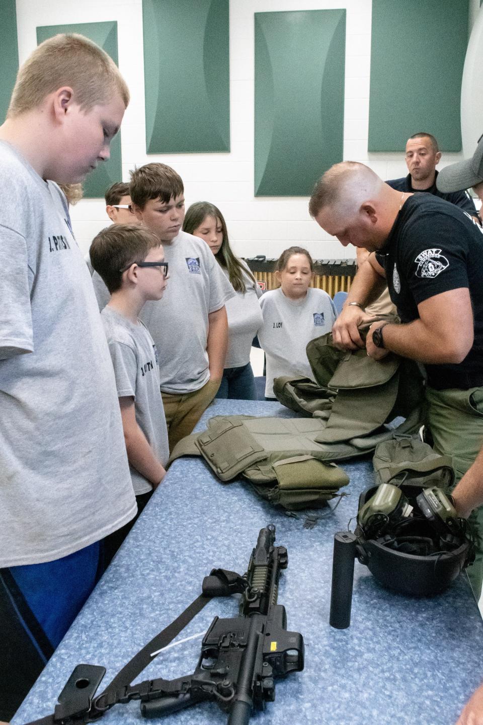 Members of the Cambridge SWAT team display their equipment and demonstrate their use to students at the Cambridge Police Youth Citizens Academy.