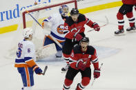 New Jersey Devils center Travis Zajac (19) and Devils left wing Miles Wood (44) react after Devils center Jack Hughes scored a goal against New York Islanders goaltender Ilya Sorokin (30) during the first period of an NHL hockey game against the New York Islanders, Sunday, Jan. 24, 2021, in Newark, N.J. Islanders defenseman Ryan Pulock (6) takes in the reaction. (AP Photo/Kathy Willens)