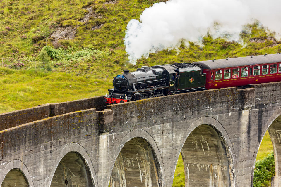 Famous steam training passing over a curved viaduct at Glenfinnan in the Scottish Highlands