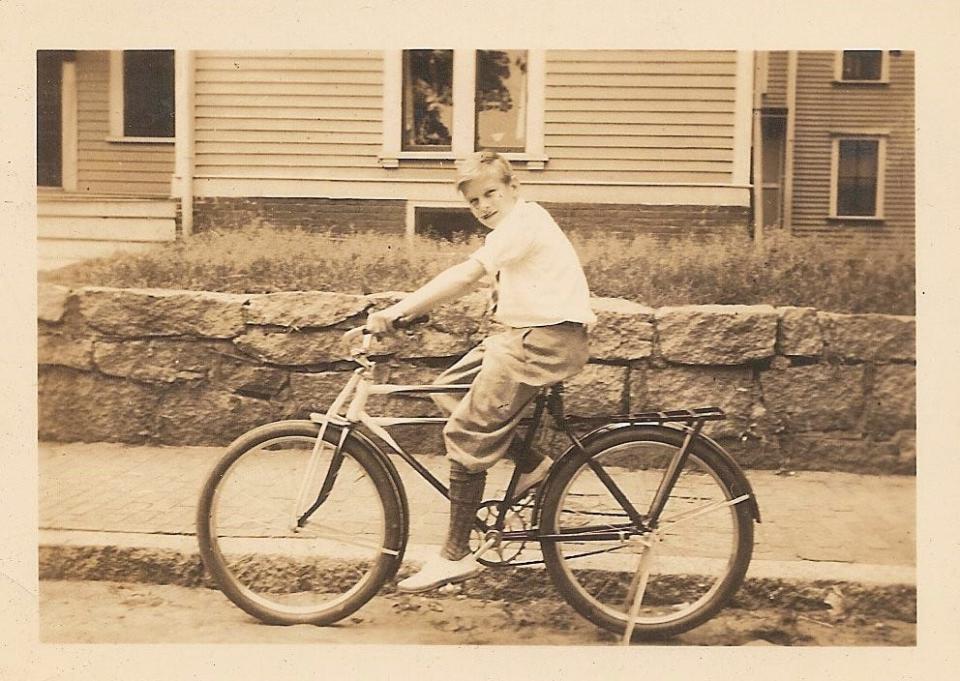 Merrill Leavens rides his bike as a boy in Dorchester. He grew up in the Port Norfolk neighborhood of Neponset.