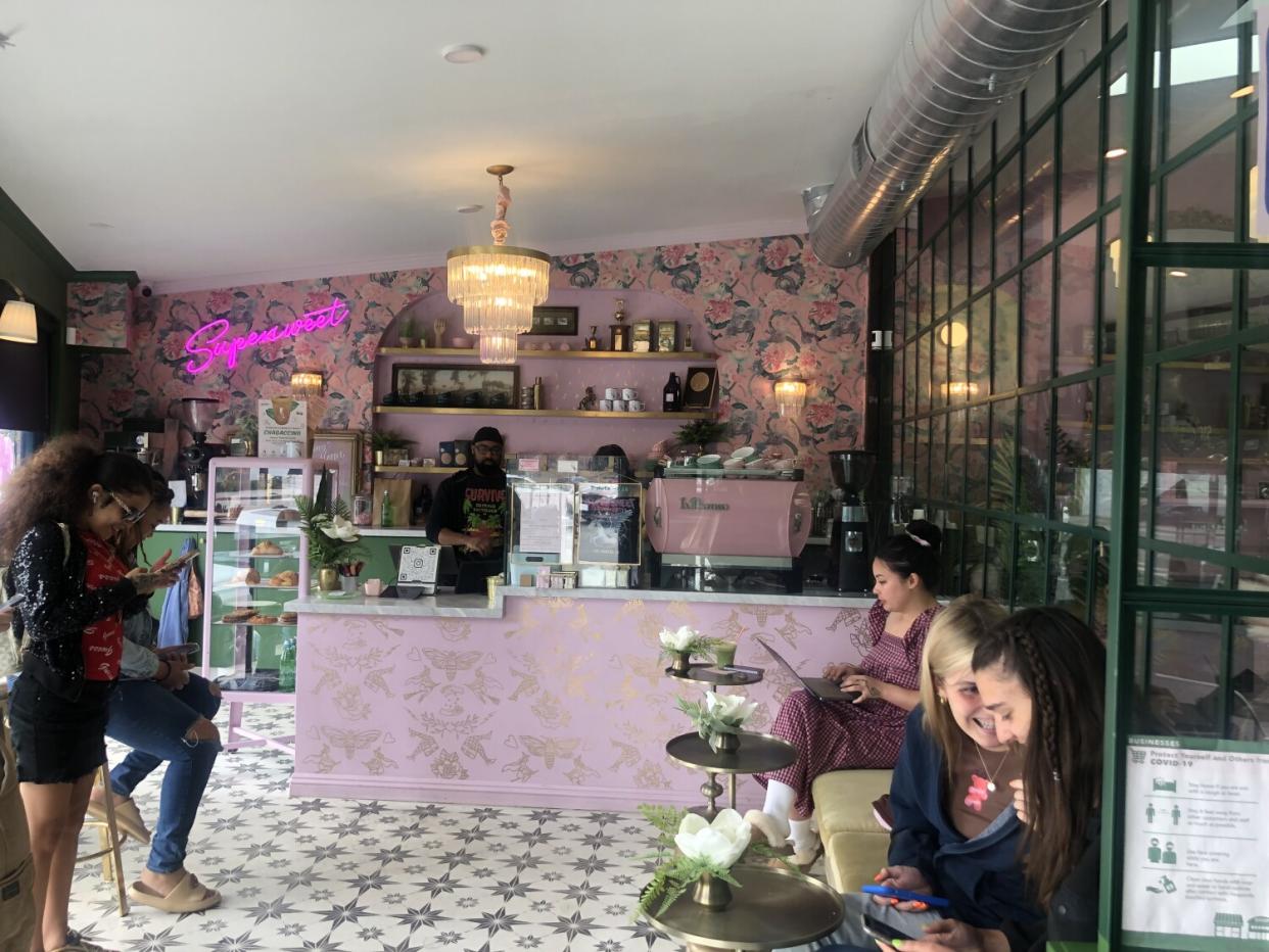 women sit at a pink coffee bar