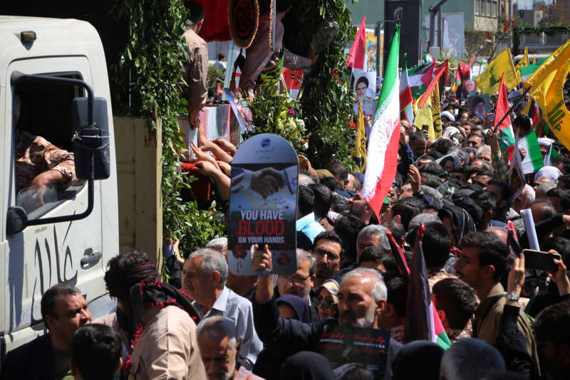 Iranian mourners gather around a truck carrying the coffins of members of the Islamic Revolutionary Guard Corps (IRGC) who were killed in an airstrike on the Iranian consulate building in Syria's capital Damascus, during their funeral in Tehran. Rouzbeh Fouladi/ZUMA Press Wire/dpa