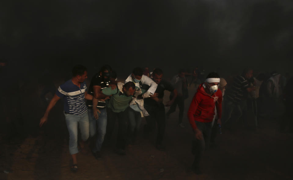 Medics and protesters evacuate a seriously wounded youth who was shot in his back, from near the fence of the Gaza Strip border with Israel east of Khan Younis, southern Gaza Strip, Friday, Oct. 19, 2018. (AP Photo/Adel Hana)