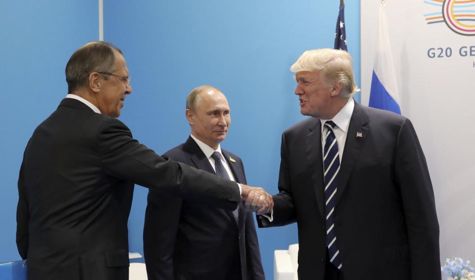 U.S. President Donald Trump shakes hands with Russian Foreign Minister Sergey Lavrov on July 7, 2017, as Russian President Vladimir Putin looks on. (Photo: Sputnik Photo Agency/Reuters)