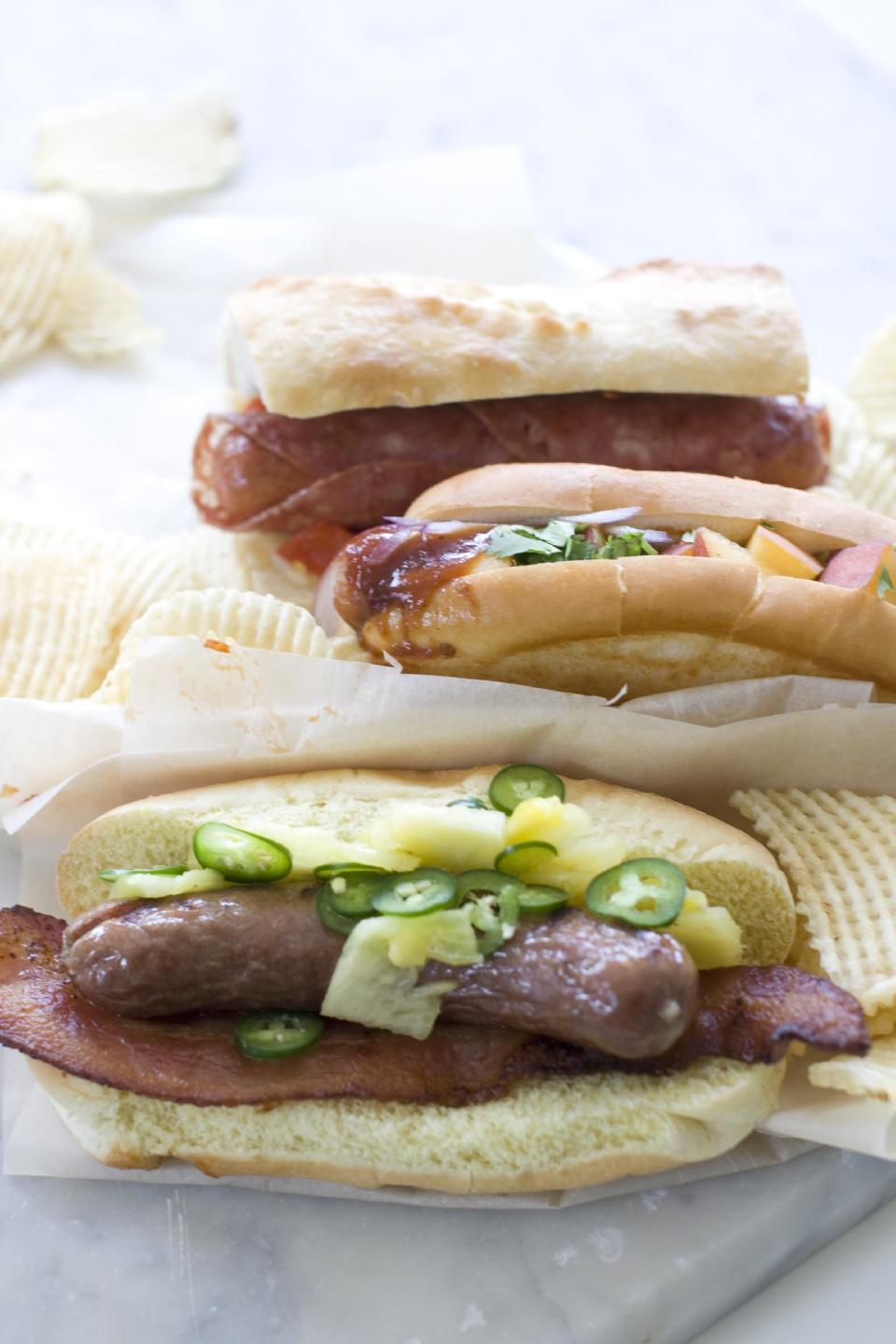 This June 29, 2013 photo shows, from top, the Italian, sweet peachand Hawaiian hot dogs in Concord, N.H. (AP Photo/Matthew Mead)