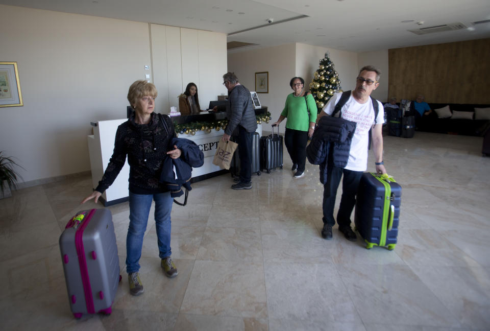 In this Thursday, Dec. 5, 2019 photo, Christian visitors in the lobby of a hotel in the West Bank city of Bethlehem. As visitors descend on Bethlehem this Christmas, they have the option of staying in restored centuries-old guesthouses, taking food tours of local markets, and perusing the dystopian art in and around a hotel designed by the British graffiti artist Banksy. (AP Photo/Majdi Mohammed)