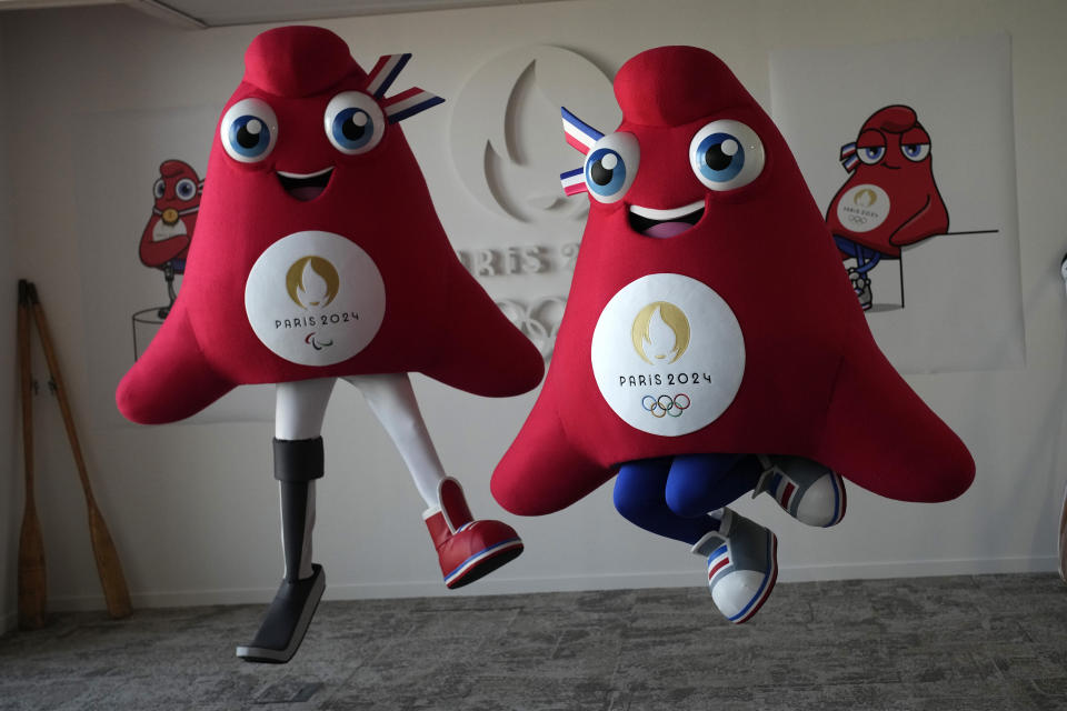 FILE - Mascots of the 2024 Paris Olympic Games, right, and Paralympics Games, a Phrygian cap, jump during a preview in Saint Denis, outside Paris, on Thursday, Nov. 10, 2022. Izzy, the much-hated blob that represented the 1996 Atlanta Games has been supplanted by the mascot for the Paris Olympics — a Phrygian cap. (AP Photo/Christophe Ena, File)