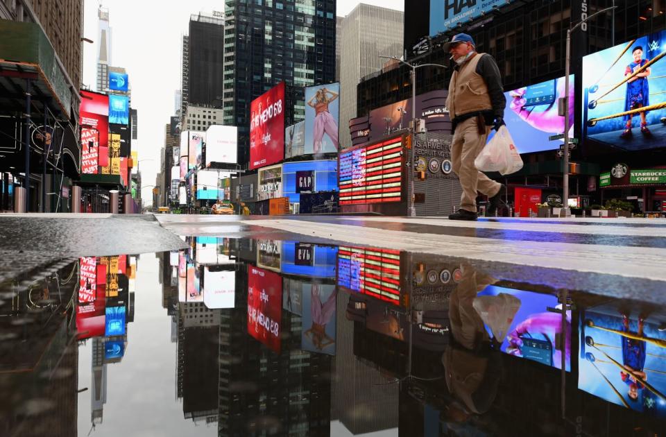 A man crosses the street at a nearly empty Times Square on Thursday in New York City.