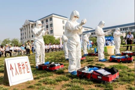 FILE PHOTO: People participate in an emergency exercise on prevention and control of H7N9 bird flu virus organised by the Health and Family Planning Commission of the local government in Hebi, Henan province, China June 17, 2017. Picture taken June 17, 2017. REUTERS/Stringer