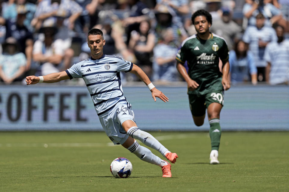 Sporting Kansas City midfielder Erik Thommy (26) is chased by Portland Timbers midfielder Evander (20) as he moves the ball during the first half of an MLS soccer match Sunday, May 28, 2023, in Kansas City, Kan. (AP Photo/Charlie Riedel)