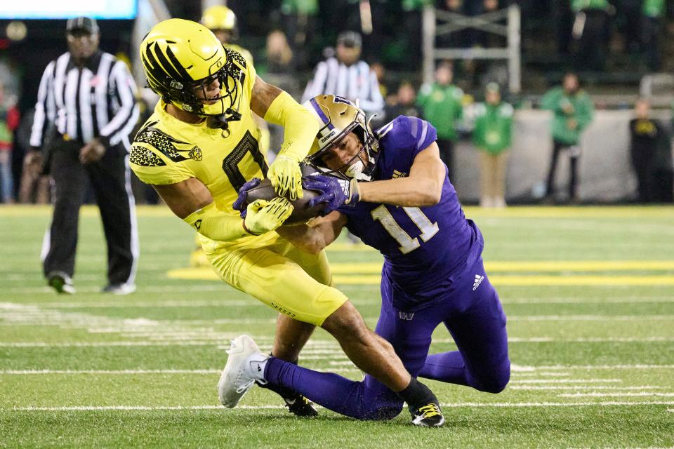 Washington Huskies receiver Jalen McMillan catches a pass for a first down against Oregon Ducks defensive back Christian Gonzalez in Eugene, Oregon, Nov. 12, 2022.