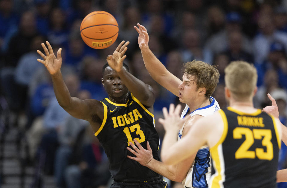 Iowa's Ladji Dembele, left, passes the ball to Ben Krikke (23) past Creighton's Isaac Traudt during the first half of an NCAA college basketball game Tuesday, Nov. 14, 2023, in Omaha, Neb. (AP Photo/Rebecca S. Gratz)