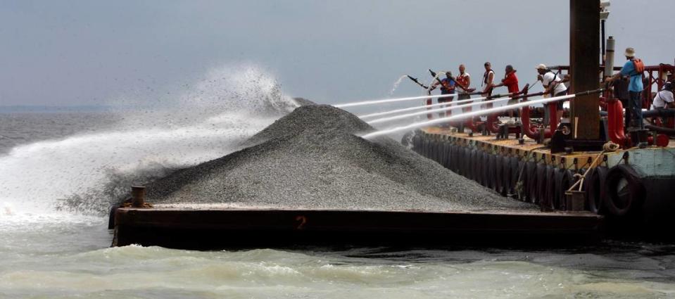 Limestone is blasted from a barge into the Mississippi Sound in 2011 as part of an effort to restore the oyster reefs.