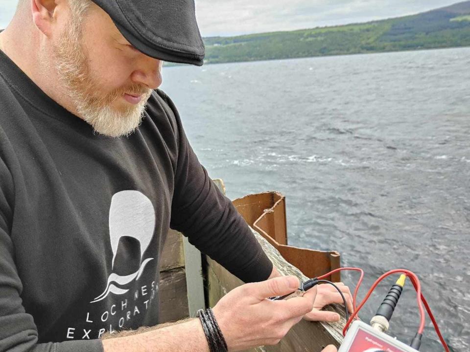 Loch Ness enthusiast Alan McKenna during a watch in an undated photo that also shows a hand holding monitoring equipment.