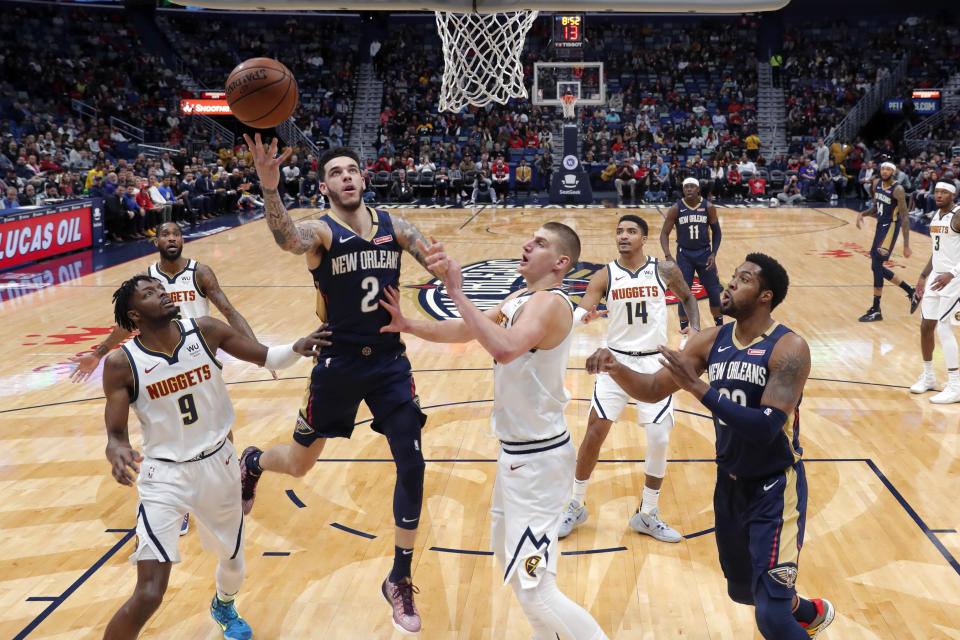 New Orleans Pelicans guard Lonzo Ball (2) goes to the basket between Denver Nuggets forward Jerami Grant (9) and center Nikola Jokic in the first half of an NBA basketball game in New Orleans, Friday, Jan. 24, 2020. (AP Photo/Gerald Herbert)