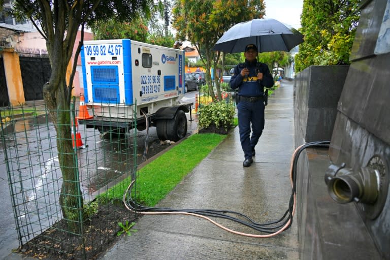 Un guarda de seguridad camina junto a un generador eléctrico el 19 de abril de 2024 en Quito (Rodrigo Buendía)