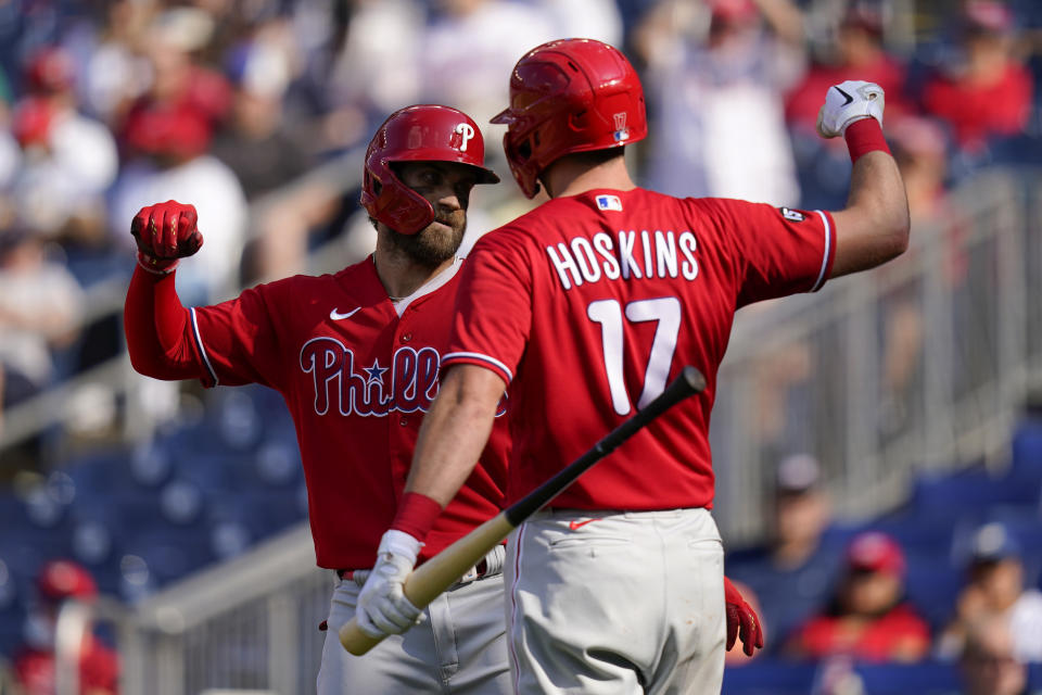 Philadelphia Phillies' Bryce Harper, left, celebrates with teammate Rhys Hoskins after hitting a solo home run in the third inning of a baseball game against the Washington Nationals, Thursday, Aug. 5, 2021, in Washington. (AP Photo/Patrick Semansky)