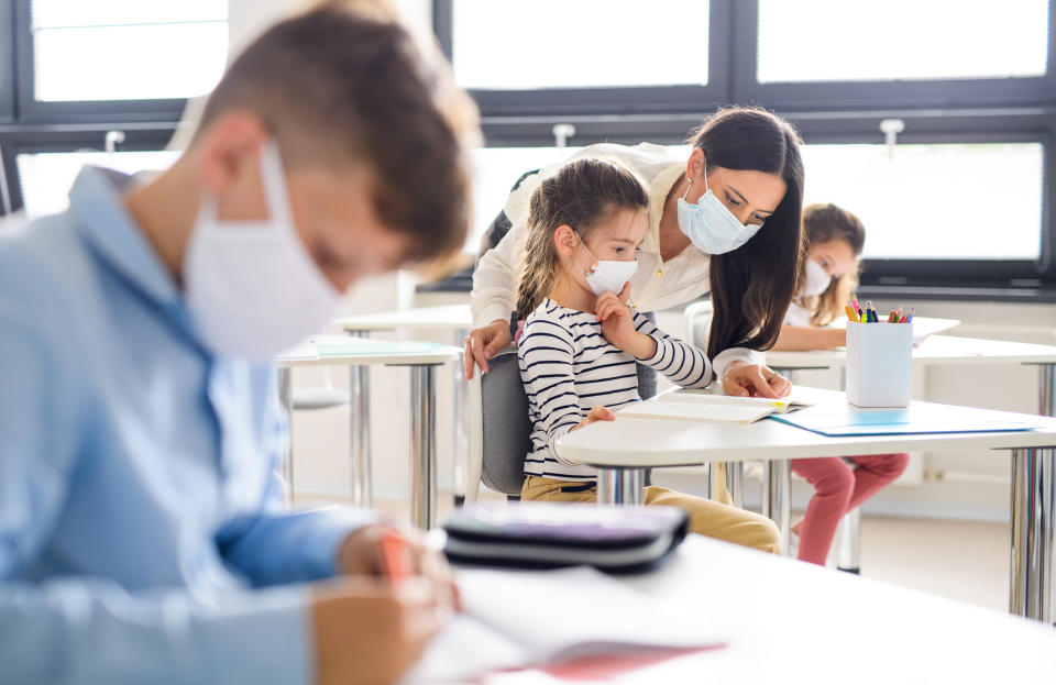 Group of children with face mask back at school after covid-19 quarantine and lockdown, learning.