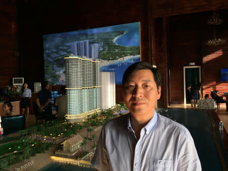 General manager Chen Hu, poses in front of model of the Blue Bay Resort being built at the Preah Sihanoukville province, Cambodia November 26, 2017. REUTERS/Matthew Tostevin