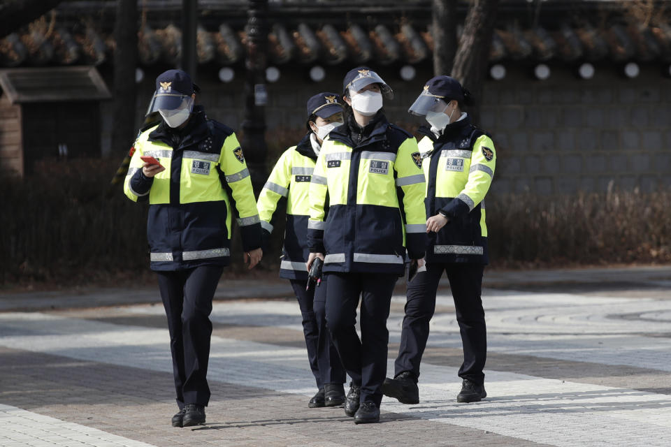 South Korean police officers wearing face masks as a precaution against the coronavirus, walk in Seoul, South Korea, Monday, Jan. 25, 2021. (AP Photo/Lee Jin-man)