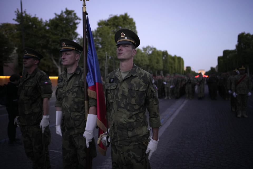 Soldiers of the Czech Republic stand on the Champs Elysees avenue during a rehearsal for the Bastille Day parade in Paris, France, Monday, July 11, 2022. Paris is preparing for a big Bastille Day parade later this week, a military show on the Champs-Elysees avenue that this year will honor war-torn Ukraine and include troops from countries on NATO's eastern flank: Poland, Hungary, Slovakia, Romania, Bulgaria, Czechia, Lithuania, Estonia and Latvia. (AP Photo/Christophe Ena)