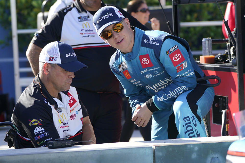 Driver John Hunter Nemechek, right, stands on pit road during NASCAR Cup Series practice at Homestead-Miami Speedway, Saturday, Oct. 22, 2022, in Homestead, Fla. (AP Photo/Lynne Sladky)