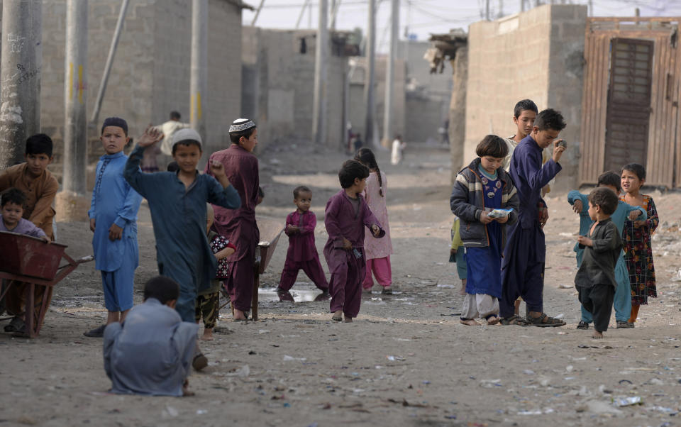 Children play on a street in a neighbourhood, where mostly Afghan populations, in Karachi, Pakistan, Friday, Jan. 26, 2024. For more than 1 million Afghans who fled war and poverty to Pakistan, these are uncertain times. Since Pakistan announced a crackdown on migrants last year, some 600,000 have been deported and at least a million remain in Pakistan in hiding. They've retreated from public view, abandoning their jobs and rarely leaving their neighborhoods out of fear they could be next. It's harder for them to earn money, rent accommodation, buy food or get medical help because they run the risk of getting caught by police or being reported to authorities by Pakistanis. (AP Photo/Fareed Khan)