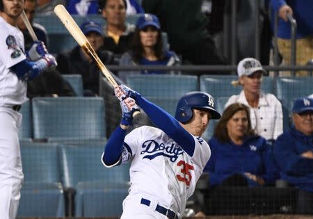 Oct 16, 2018; Los Angeles, CA, USA; Los Angeles Dodgers center fielder Cody Bellinger (35) hits an RBI single to defeat the Milwaukee Brewers in the thirteenth inning in game four of the 2018 NLCS playoff baseball series at Dodger Stadium. Mandatory Credit: Robert Hanashiro-USA TODAY Sports