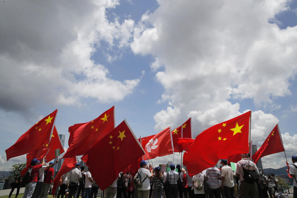 Pro-China supporters hold Chinese and Hong Kong national flags during a rally to celebrate the approval of a national security law for Hong Kong, in Hong Kong, Tuesday, June 30, 2020. Hong Kong media are reporting that China has approved a contentious law that would allow authorities to crack down on subversive and secessionist activity in Hong Kong, sparking fears that it would be used to curb opposition voices in the semi-autonomous territory. (AP Photo/Kin Cheung)