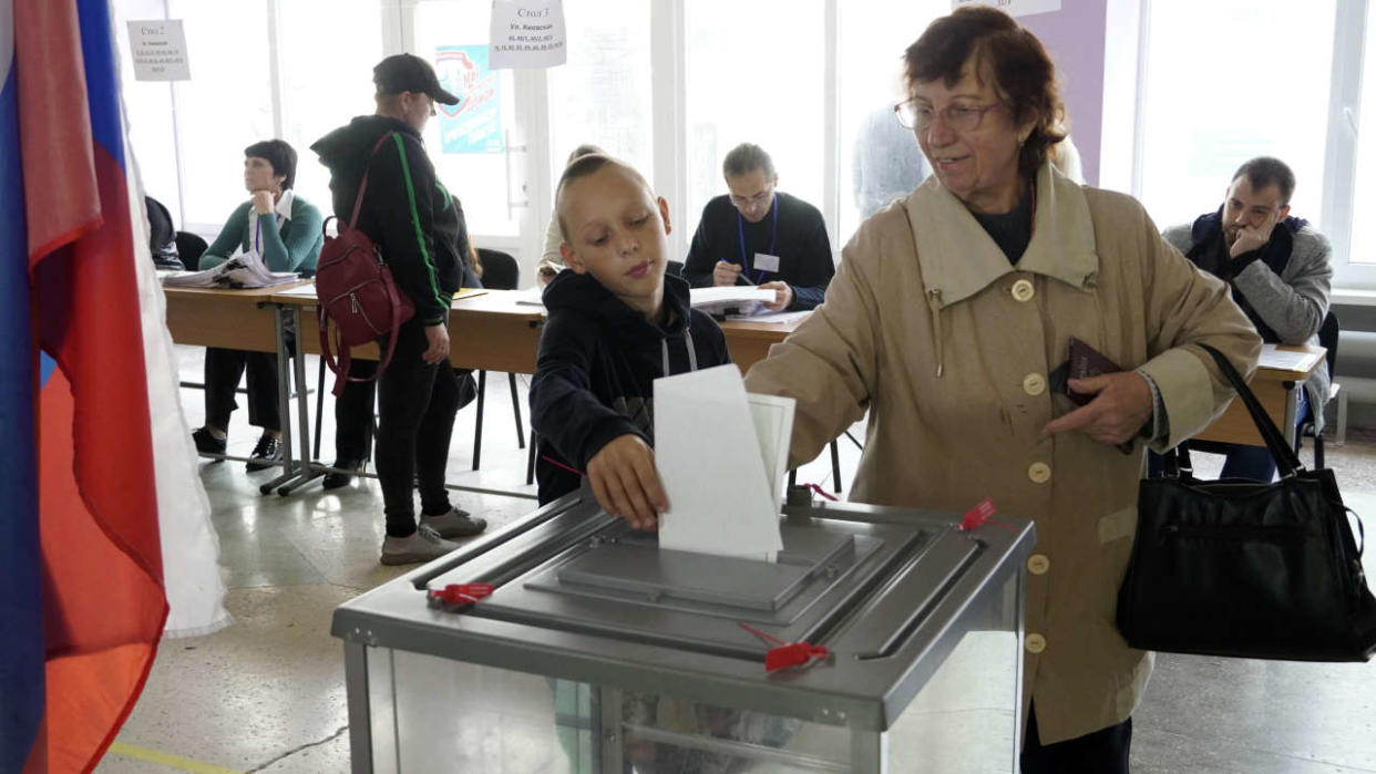 A woman casts her ballot for a referendum at a polling station in Mariupol on September 27, 2022. - Western nations dismissed the referendums in Kremlin-controlled regions of eastern and southern Ukraine as the voting on whether Russia should annex four regions of Ukraine started on September 23, 2022. (Photo by STRINGER / AFP)