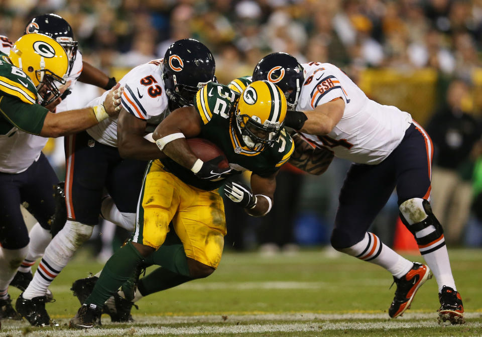 GREEN BAY, WI - SEPTEMBER 13: Running back Cedric Benson #32 of the Green Bay Packers carries the ball against the defense of outside linebacker Nick Roach #53 and middle linebacker Brian Urlacher #54 of the Chicago Bears in the first quarter at Lambeau Field on September 13, 2012 in Green Bay, Wisconsin. (Photo by Jonathan Daniel/Getty Images)