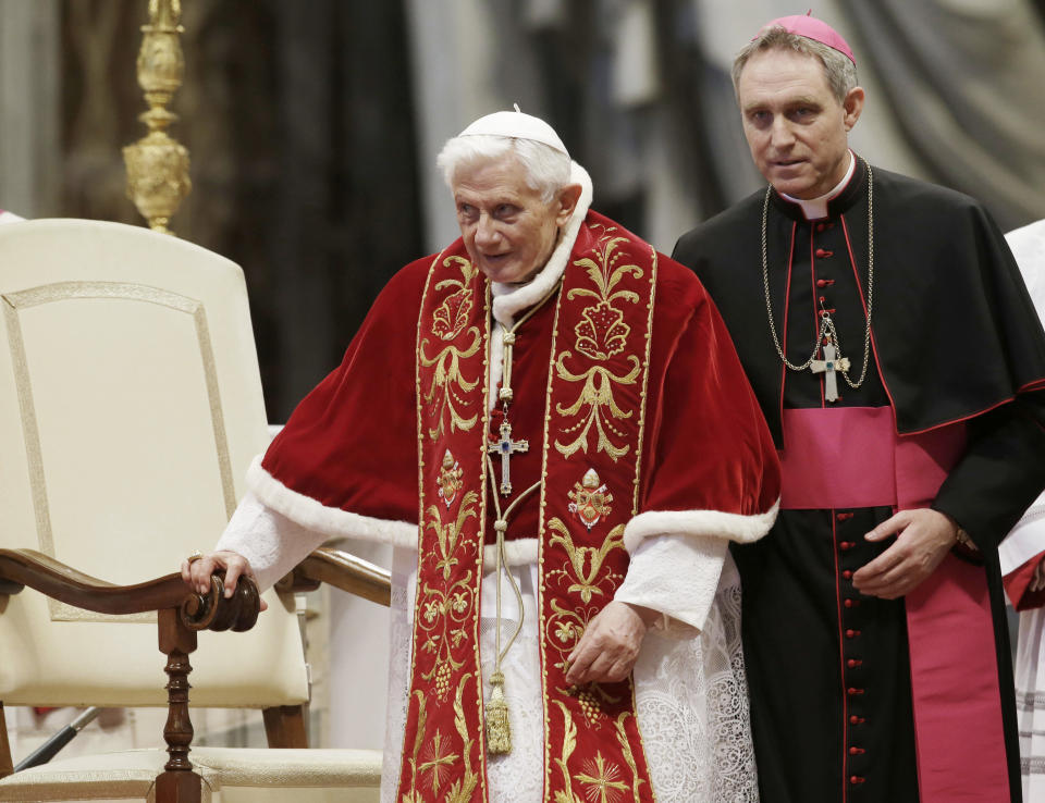 FILE - Pope Benedict XVI flanked by personal secretary Archbishop Georg Gaenswein during a Mass to mark the 900th anniversary of the Order of the Knights of Malta in St. Peter's Basilica at the Vatican, on Feb. 9, 2013. He was the reluctant pope, a shy bookworm who preferred solitary walks in the Alps and Mozart piano concertos to the public glare and majesty of Vatican pageantry. When Cardinal Joseph Ratzinger became Pope Benedict XVI and was thrust into the footsteps of his beloved and charismatic predecessor, he said he felt a guillotine had come down on him. The Vatican announced Saturday Dec. 31, 2022 that Benedict, the former Joseph Ratzinger, had died at age 95.(AP Photo/Gregorio Borgia, File)