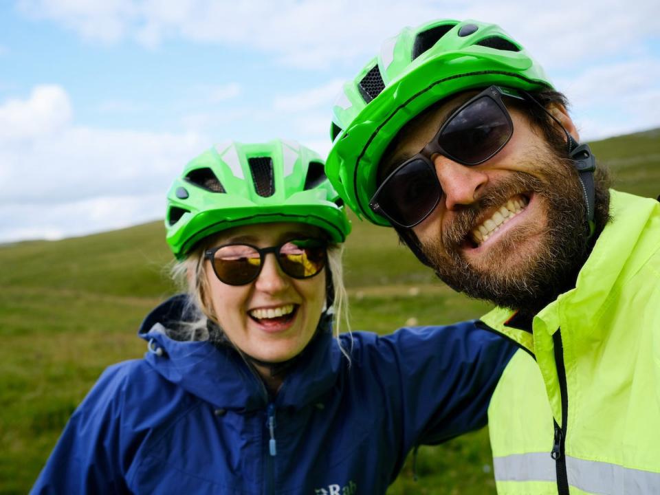 Joshua Kian and Sarah Morgan smiling while wearing bike helmets.