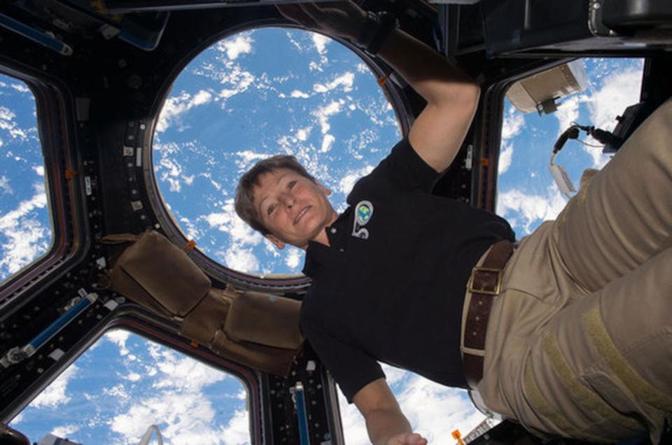 Astronaut Peggy Whitson floats in the cupola on board the International Space Station, backdropped by the Earth below. <cite>NASA</cite>