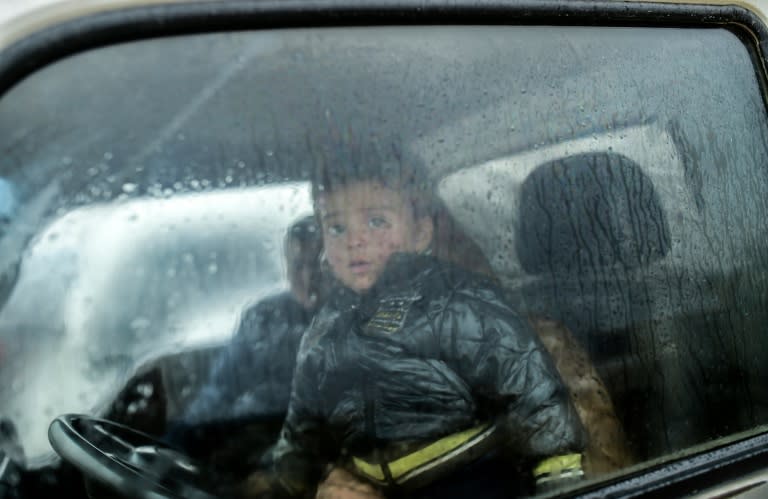 A refugee child is pictured inside a car near the Turkish border on February 6, 2016