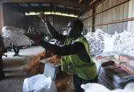 Christopher Harris, with the City of Saraland, throws a sand bag for residents as they prepare for Tropical Storm Gordon, Tuesday, Sept. 4, 2018, in Saralad, Ala. (AP Photo/Dan Anderson)